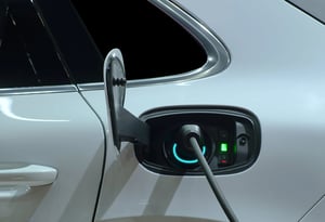 closeup-hand-grip-plug-connected-with-socket-charge-white-electric-car-rechargeable-battery-min