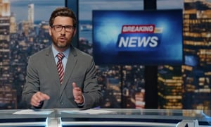 TV news presenter reporting breaking news in a studio