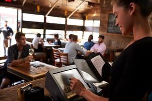 Waitress using POS touchscreen to process payment in a restaurant