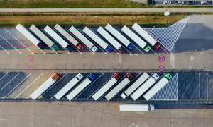 Aerial view of semi-trucks parked at a logistics hub.