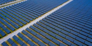 Aerial view of rows of solar panels in a large solar farm