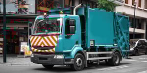 Waste collection truck on city street